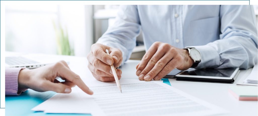 Two people examining and signing paperwork