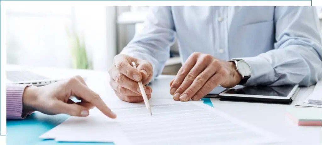 Two people examining and signing paperwork