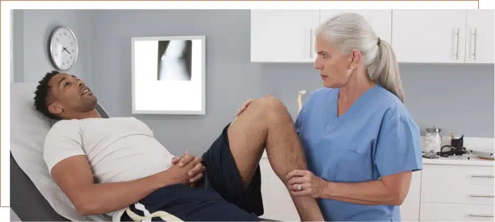 A medical professional examining a patient with knee pain