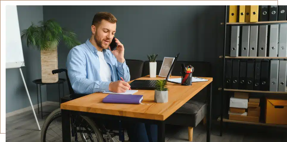 A man with a disability on the phone and filling out paperwork