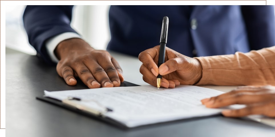 A person signs a legal document at a long term disability attorney's office