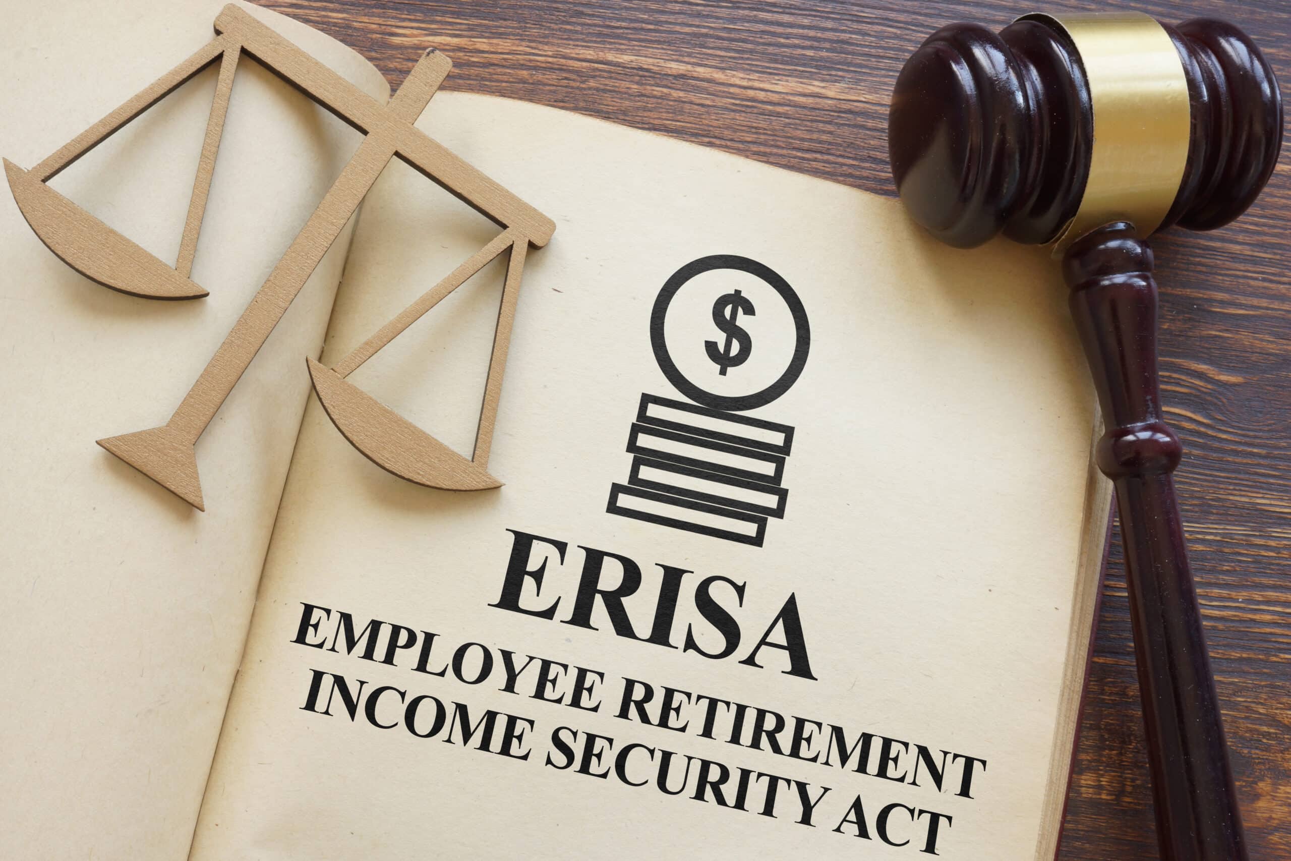 Legal concept with a book open to a page titled ERISA Employee Retirement Income Security Act, next to a judge’s gavel and wooden scales of justice.