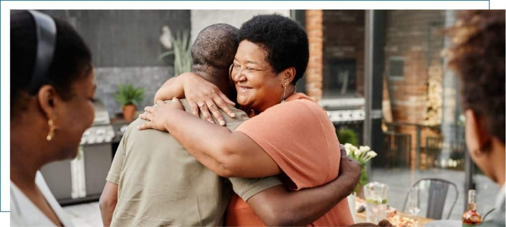 Two people smiling and embracing at a family dinner