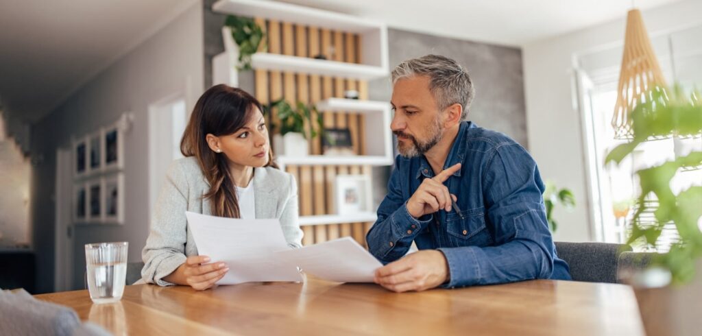 Attorney and client reviewing legal documents together at a wooden table during a consultation meeting