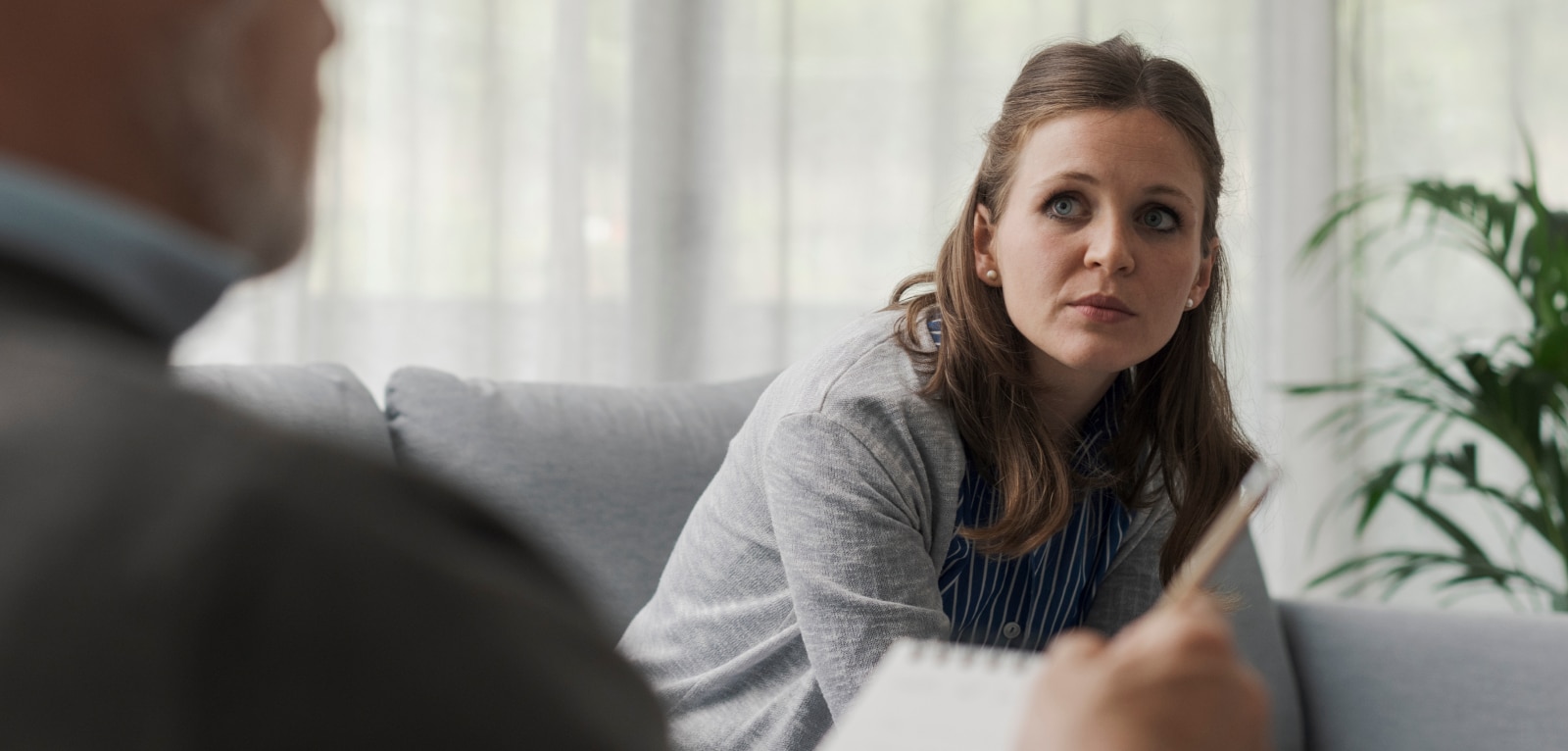Woman speaking with an attorney during a legal consultation, listening attentively in a professional office setting