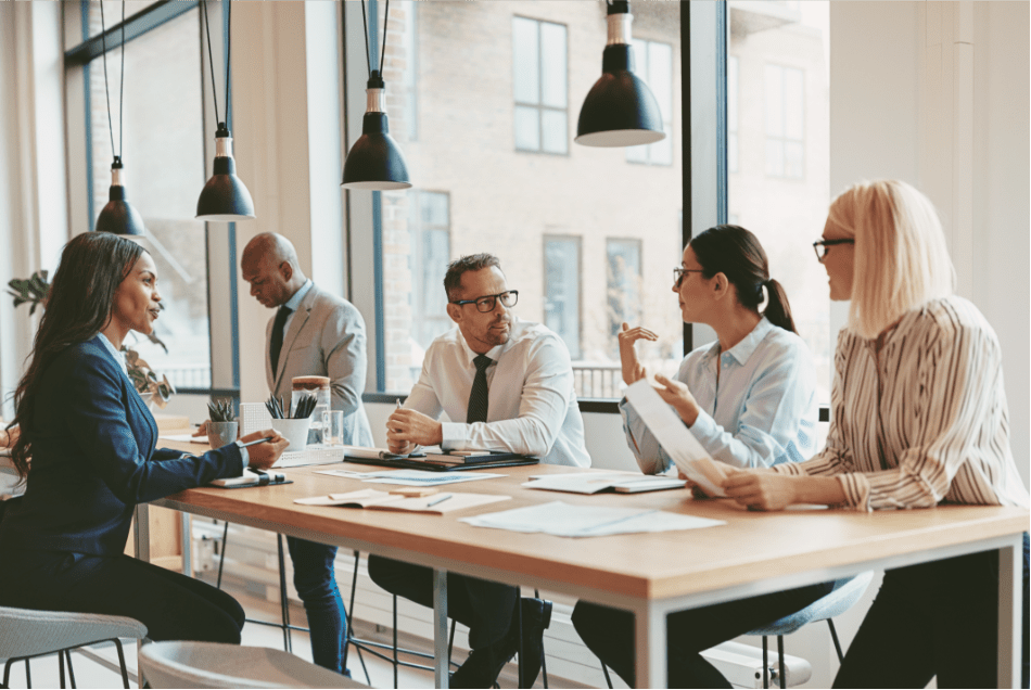Diverse legal team collaborating around a conference table in a modern, well-lit office during a professional meeting