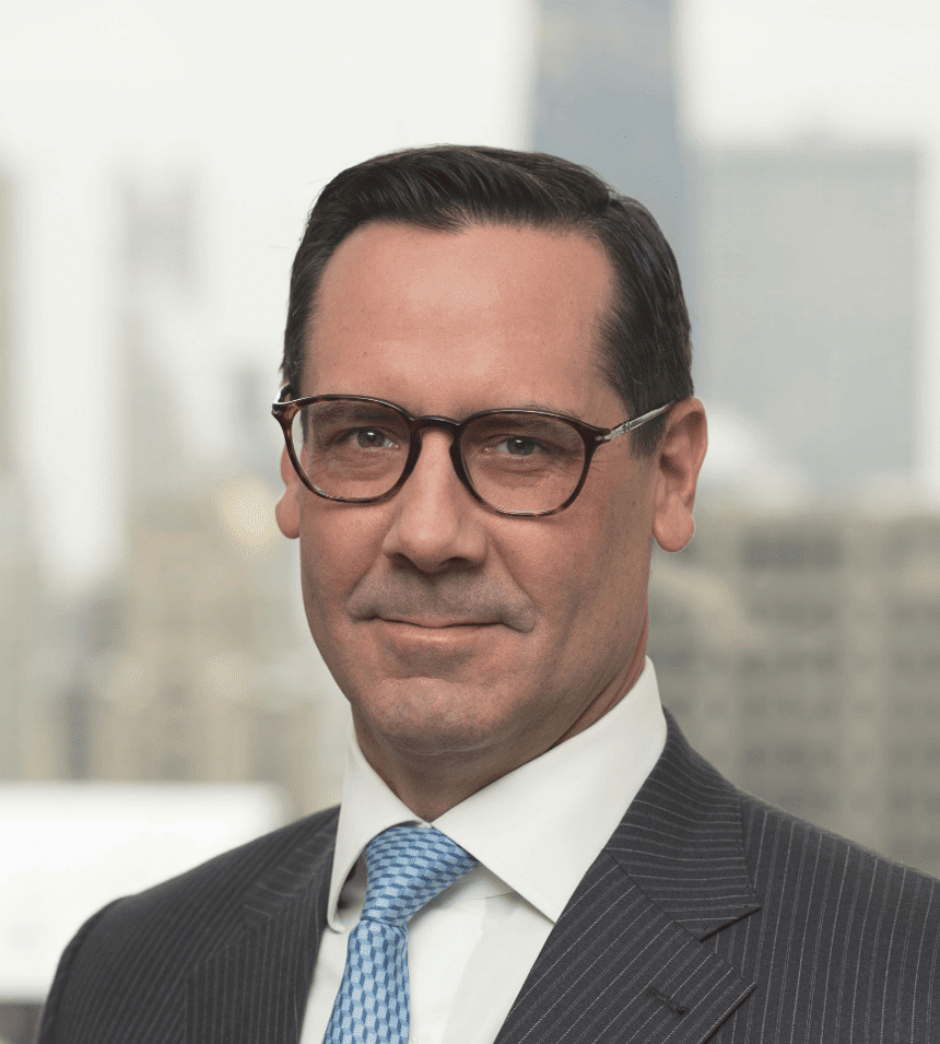 Bryant Legal attorney in dark pinstripe suit and blue tie, with NYC skyline visible in background